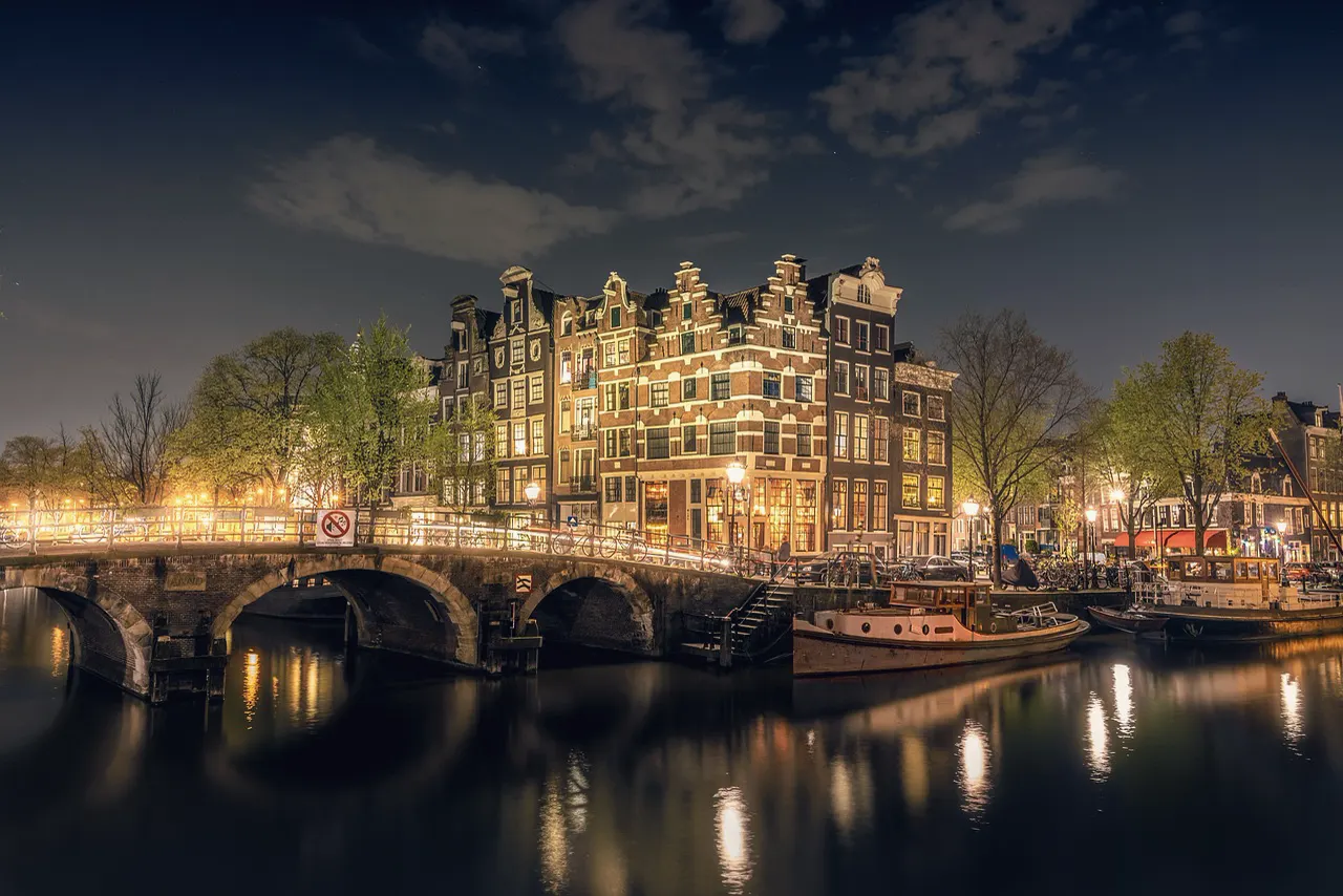 An Amsterdam canal and bridge at night