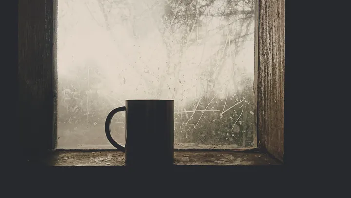 A cold mug on a misty window sill